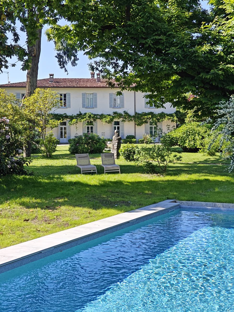 The swimming pool in the private park, looking across the lawn to the villa